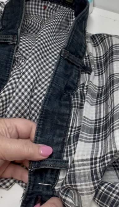 hands pinning a denim waistband to the neck edge of a gauze jacket
